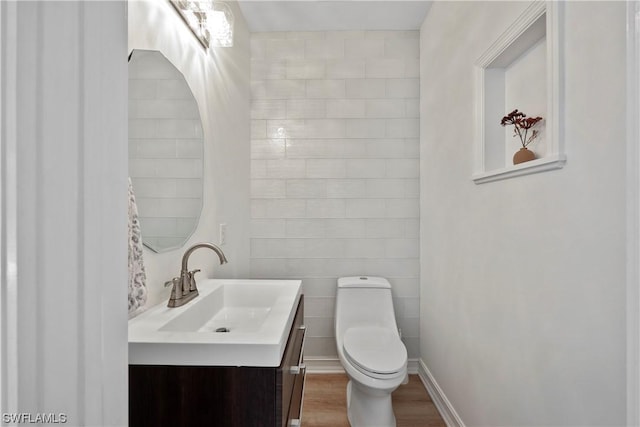 bathroom with hardwood / wood-style flooring, vanity, and toilet