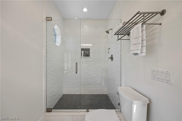 bathroom featuring walk in shower and toilet