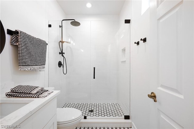 bathroom featuring tile patterned flooring, vanity, toilet, and a shower with door