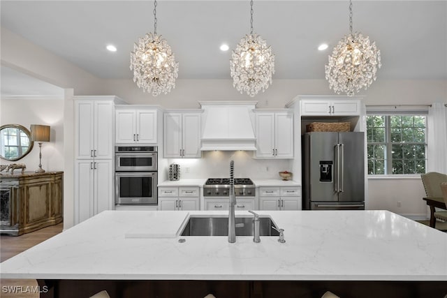 kitchen with stainless steel appliances, light stone counters, hanging light fixtures, and custom exhaust hood