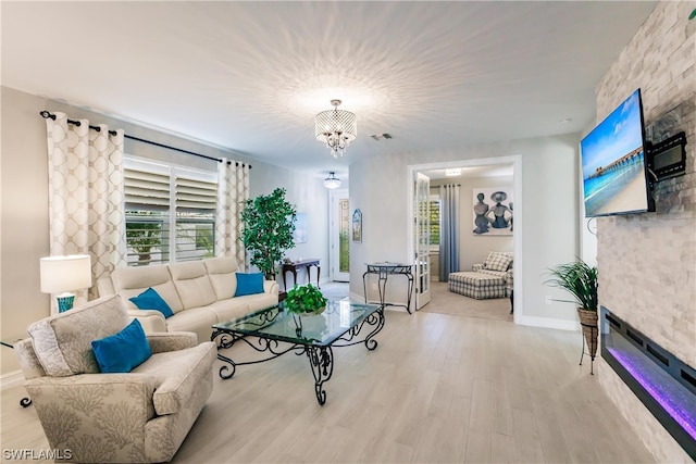 living room with a notable chandelier and light hardwood / wood-style floors