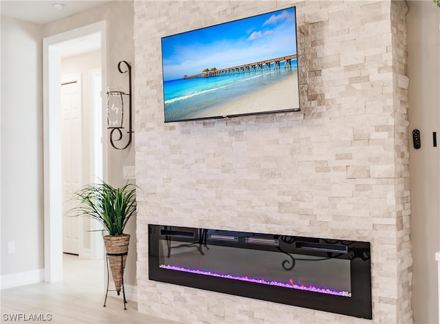 details featuring light hardwood / wood-style flooring and a stone fireplace