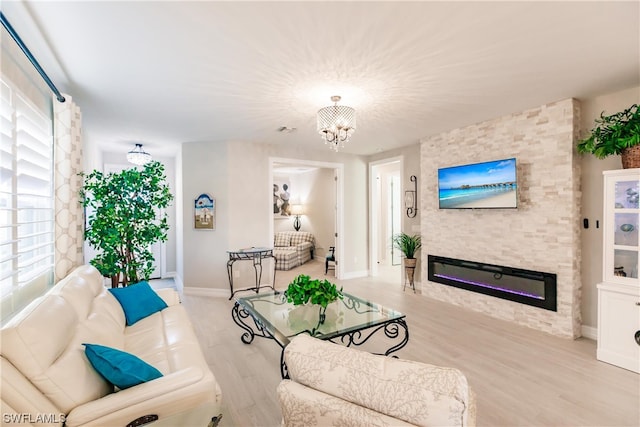 living room with a chandelier, light hardwood / wood-style flooring, and a fireplace