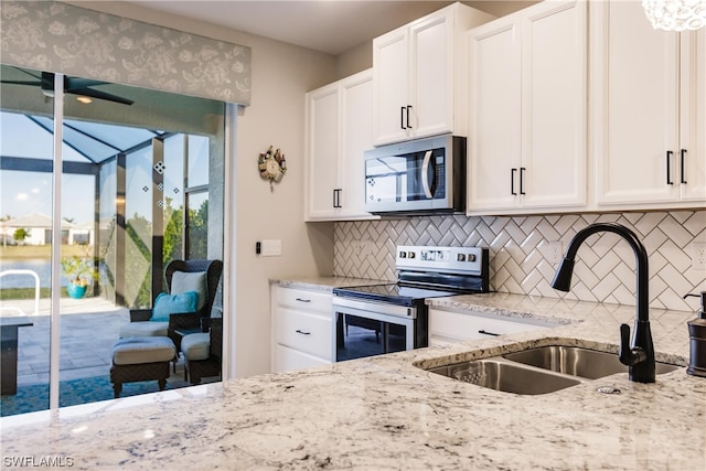 kitchen featuring appliances with stainless steel finishes, white cabinetry, and sink