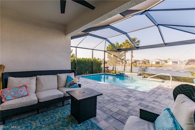 view of swimming pool with an outdoor hangout area, pool water feature, glass enclosure, and a patio