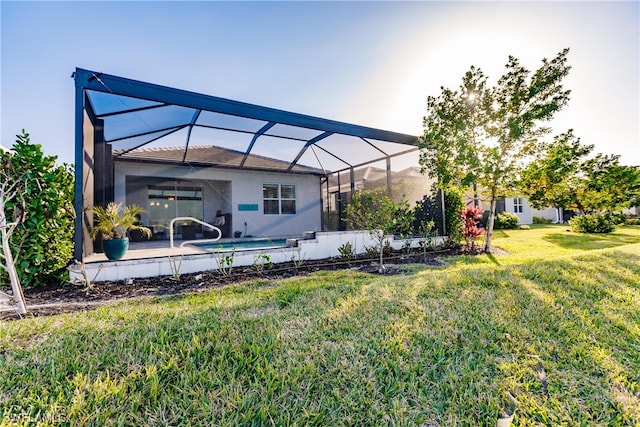 back of house with a lawn and a lanai