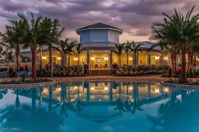 pool at dusk with a patio area