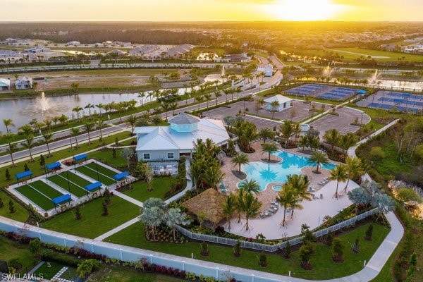 aerial view at dusk featuring a water view