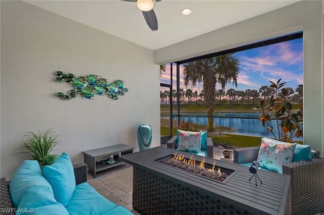 sunroom / solarium featuring a water view and ceiling fan