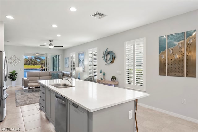 kitchen with sink, ceiling fan, a kitchen island with sink, gray cabinetry, and stainless steel appliances