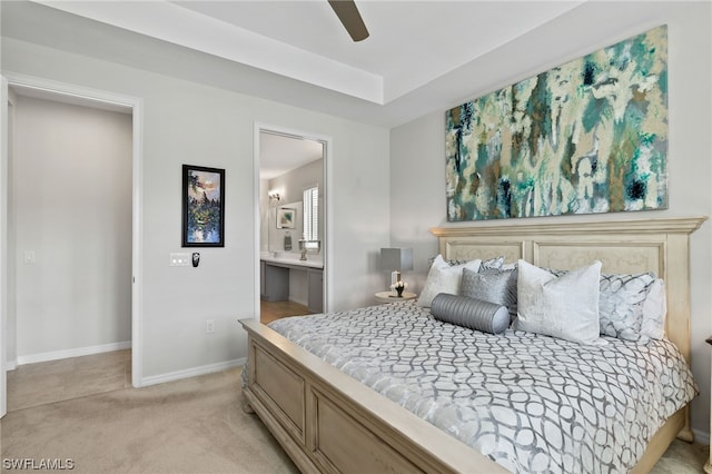 bedroom with ceiling fan, ensuite bath, and light carpet