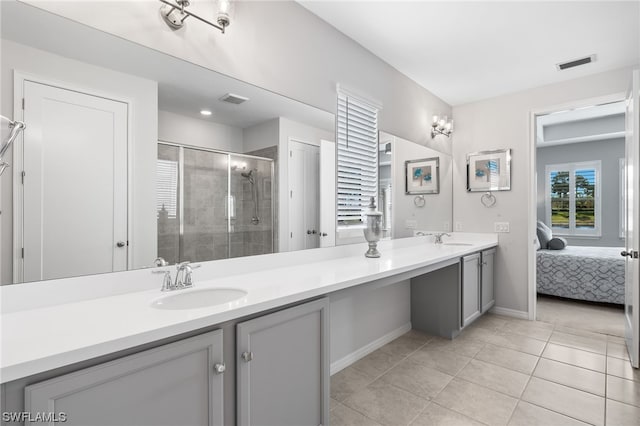 bathroom featuring a shower with door, vanity, and tile patterned floors