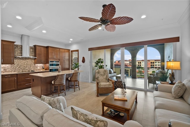 tiled living room featuring ceiling fan and crown molding