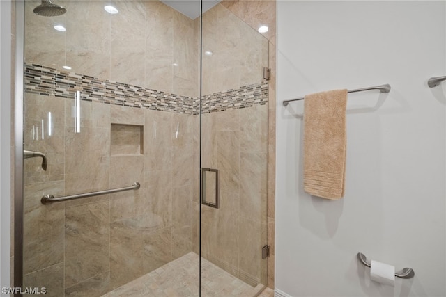 bathroom featuring a shower with door