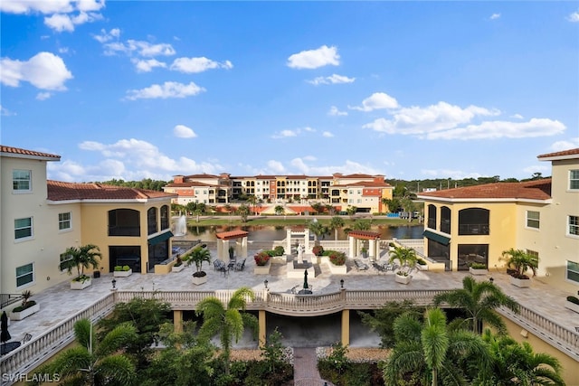 view of building exterior featuring a swimming pool and a water view