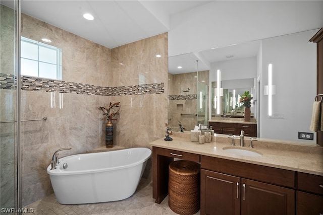 bathroom with tile walls, tile floors, vanity, and independent shower and bath