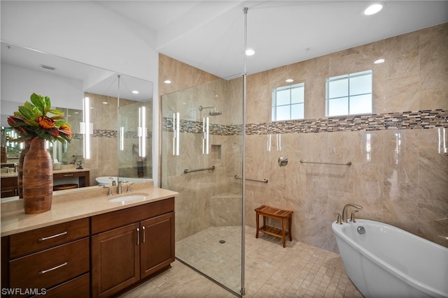 bathroom with tile walls, separate shower and tub, tile floors, and vanity