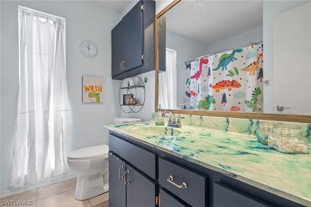 bathroom featuring tile patterned flooring, vanity, toilet, and walk in shower