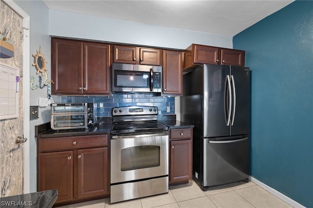 kitchen with backsplash, light tile patterned flooring, and stainless steel appliances