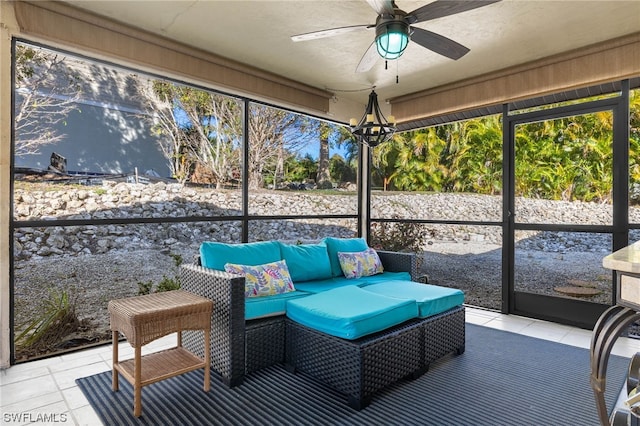 sunroom featuring ceiling fan with notable chandelier