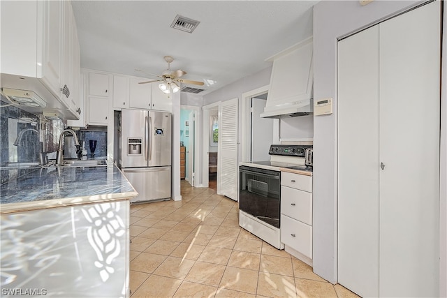 kitchen with white electric range, sink, stainless steel refrigerator with ice dispenser, light tile patterned floors, and white cabinetry