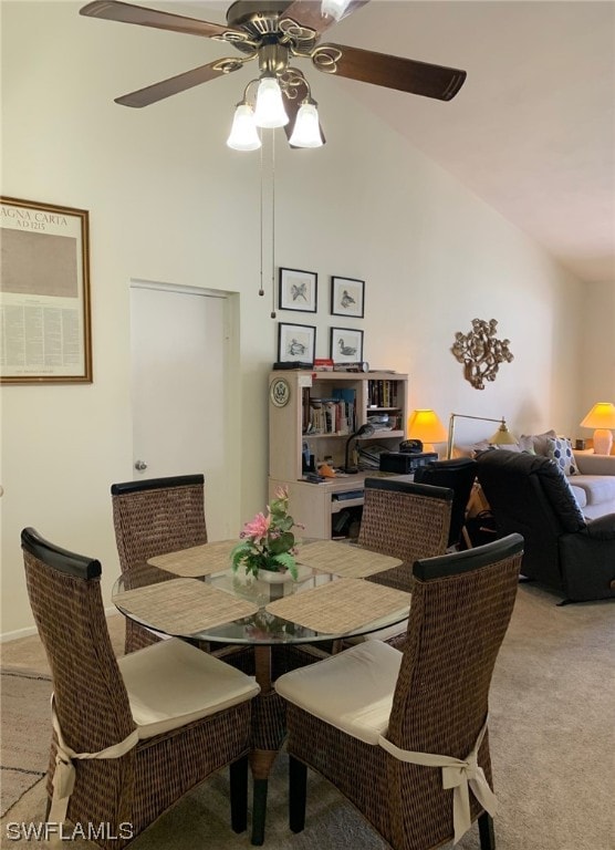 dining room featuring lofted ceiling, light colored carpet, and ceiling fan