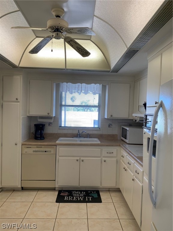 kitchen with tasteful backsplash, white appliances, white cabinetry, and sink