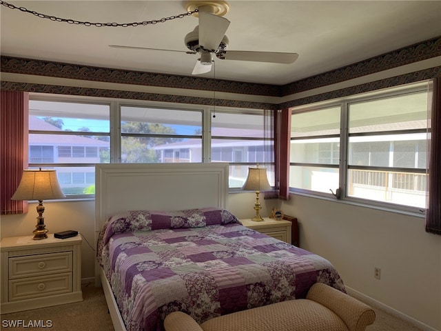 carpeted bedroom with ceiling fan and multiple windows