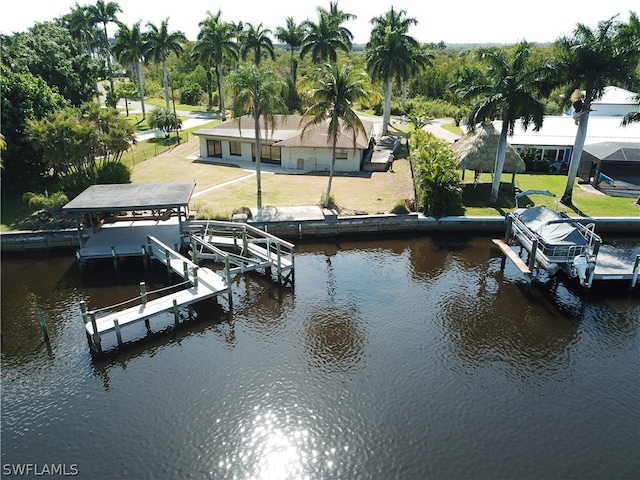 view of dock with a water view and a yard