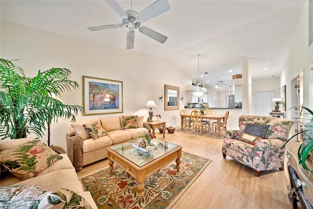 living room with lofted ceiling, light hardwood / wood-style floors, and ceiling fan