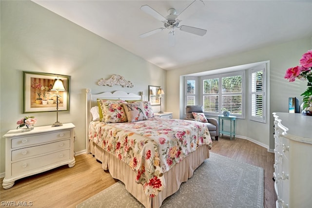 bedroom featuring light hardwood / wood-style floors, ceiling fan, and vaulted ceiling