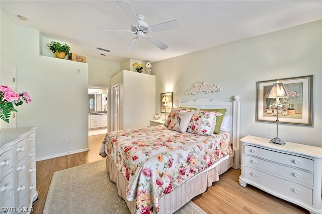 bedroom with ceiling fan, ensuite bathroom, and light hardwood / wood-style flooring