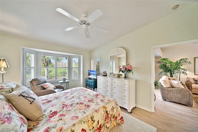 bedroom with lofted ceiling, light hardwood / wood-style floors, and ceiling fan