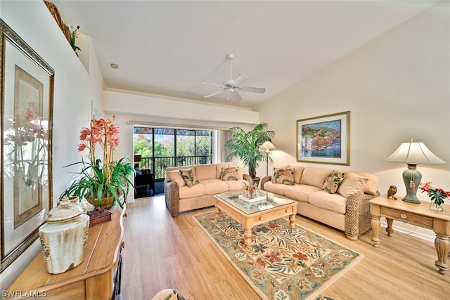 living room featuring vaulted ceiling, ceiling fan, and light wood-type flooring