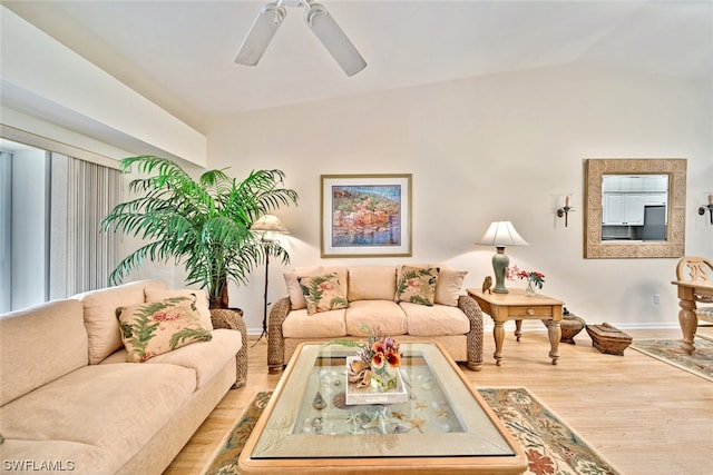 living room featuring vaulted ceiling, ceiling fan, and light wood-type flooring