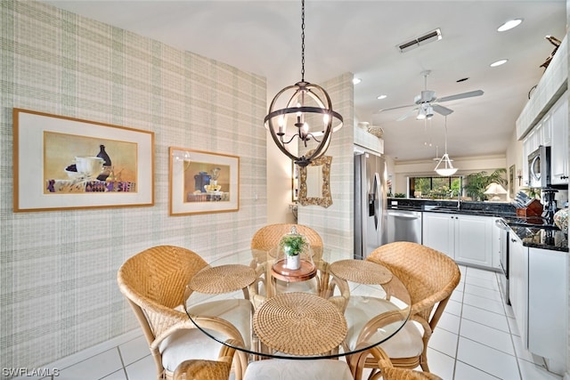 dining room featuring ceiling fan with notable chandelier and light tile flooring