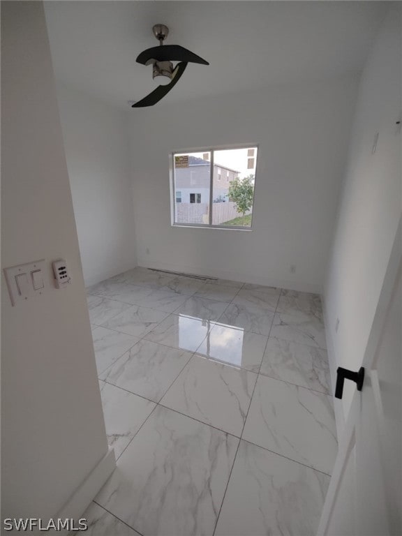 empty room with ceiling fan and light tile floors