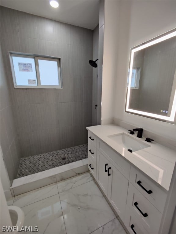 bathroom featuring tile flooring, tiled shower, vanity, and toilet