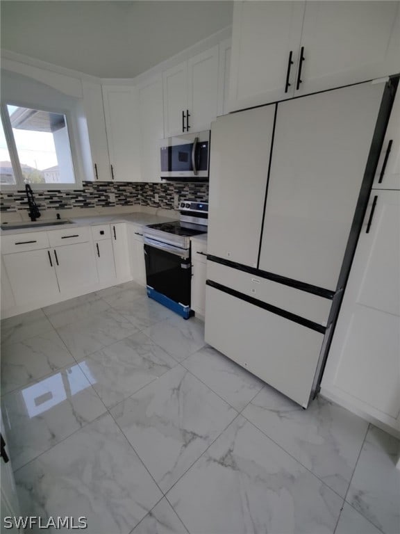 kitchen featuring light tile floors, white electric range oven, tasteful backsplash, white cabinetry, and high end fridge