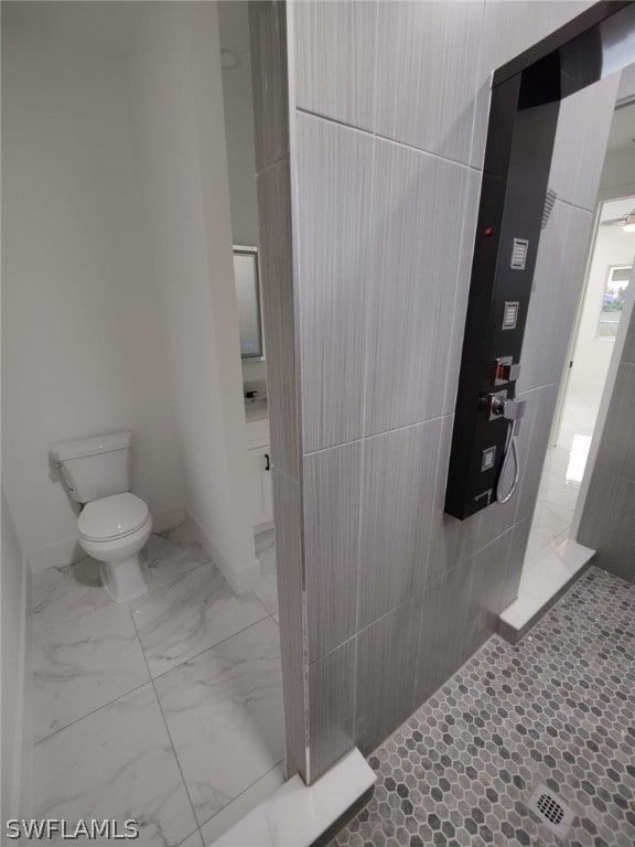 bathroom featuring a shower, tile floors, and toilet