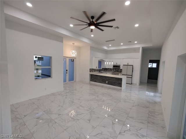 kitchen with decorative light fixtures, white cabinets, stainless steel appliances, light tile floors, and ceiling fan