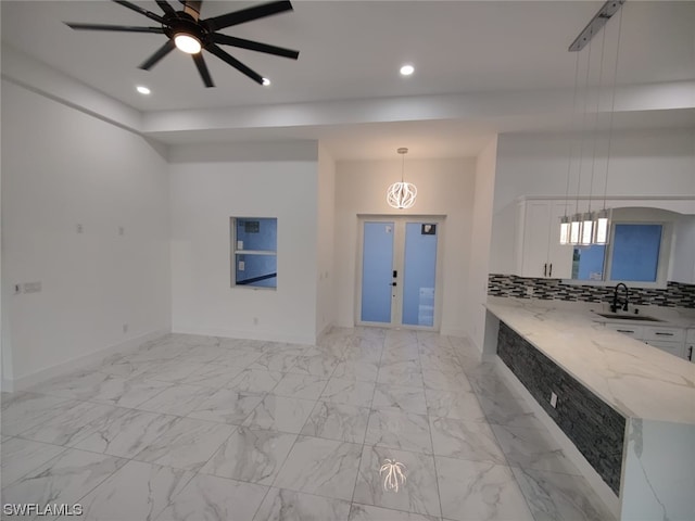 kitchen with decorative light fixtures, french doors, white cabinetry, tasteful backsplash, and ceiling fan