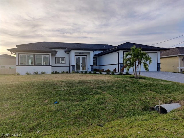 view of front of property with a yard and a garage