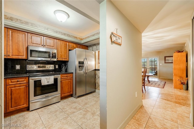 kitchen featuring appliances with stainless steel finishes, light tile patterned floors, tasteful backsplash, and lofted ceiling