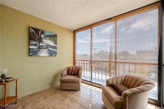 sitting room featuring a textured ceiling, light tile patterned floors, and floor to ceiling windows