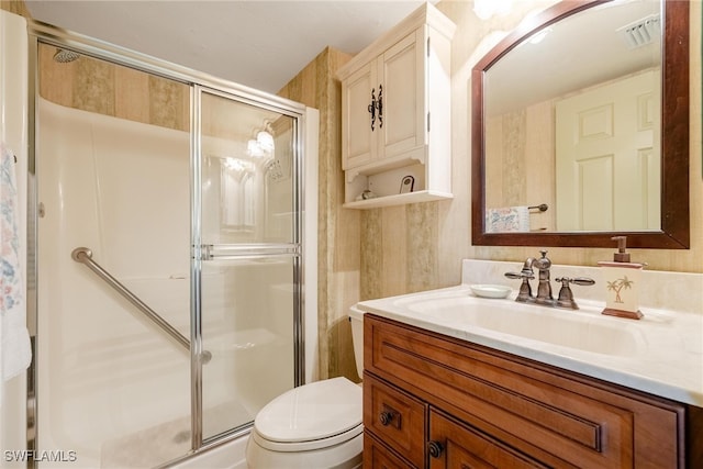 bathroom with a shower with door, toilet, and vanity