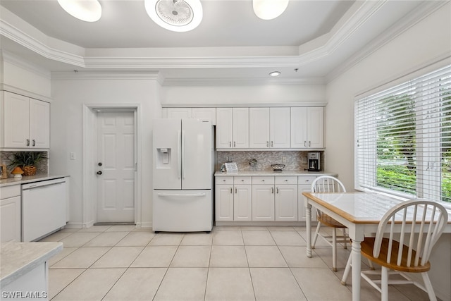 kitchen featuring light tile flooring, white appliances, white cabinetry, backsplash, and a tray ceiling