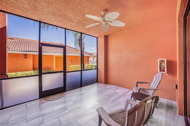 unfurnished sunroom featuring ceiling fan