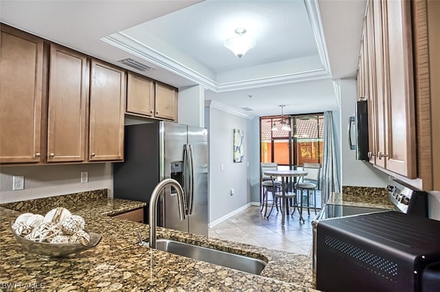 kitchen with sink, crown molding, hanging light fixtures, stainless steel appliances, and a tray ceiling