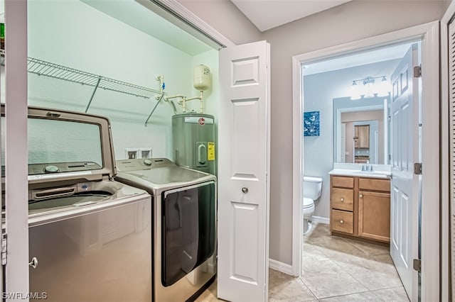 laundry room with light tile floors, water heater, separate washer and dryer, and sink